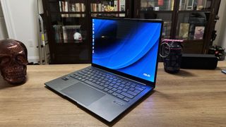 Asus Zenbook 14 OLED (Q425M) open on a wooden desk at an angle