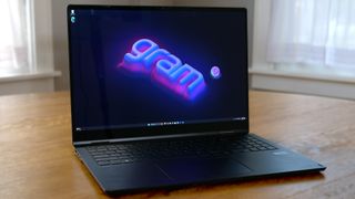 LG Gram Pro 16 2-in-1 (16T90SP) open on a wooden table showing "gram" logo on the screen